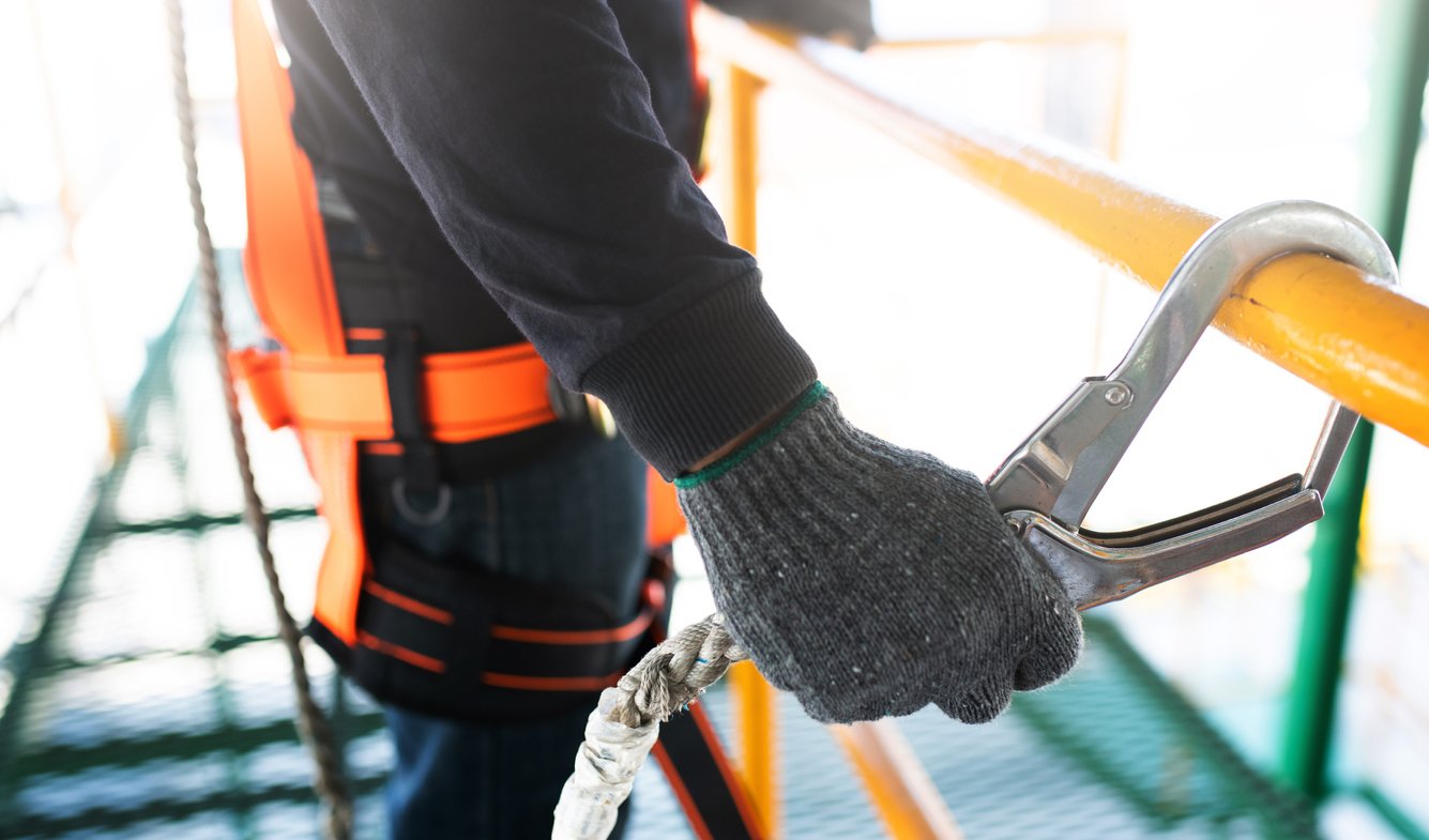 Construction worker hooking onto rail