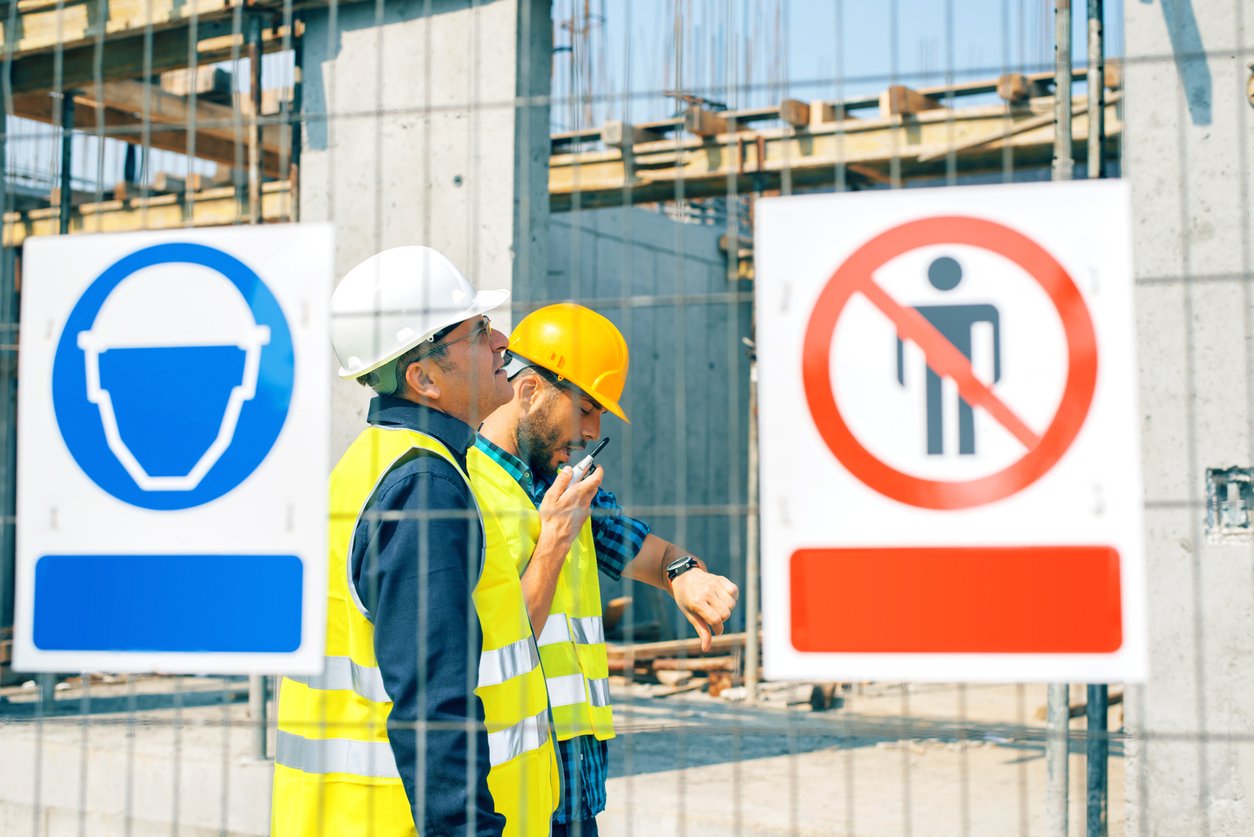 Engineer and construction site manager dealing with blueprints and projects.