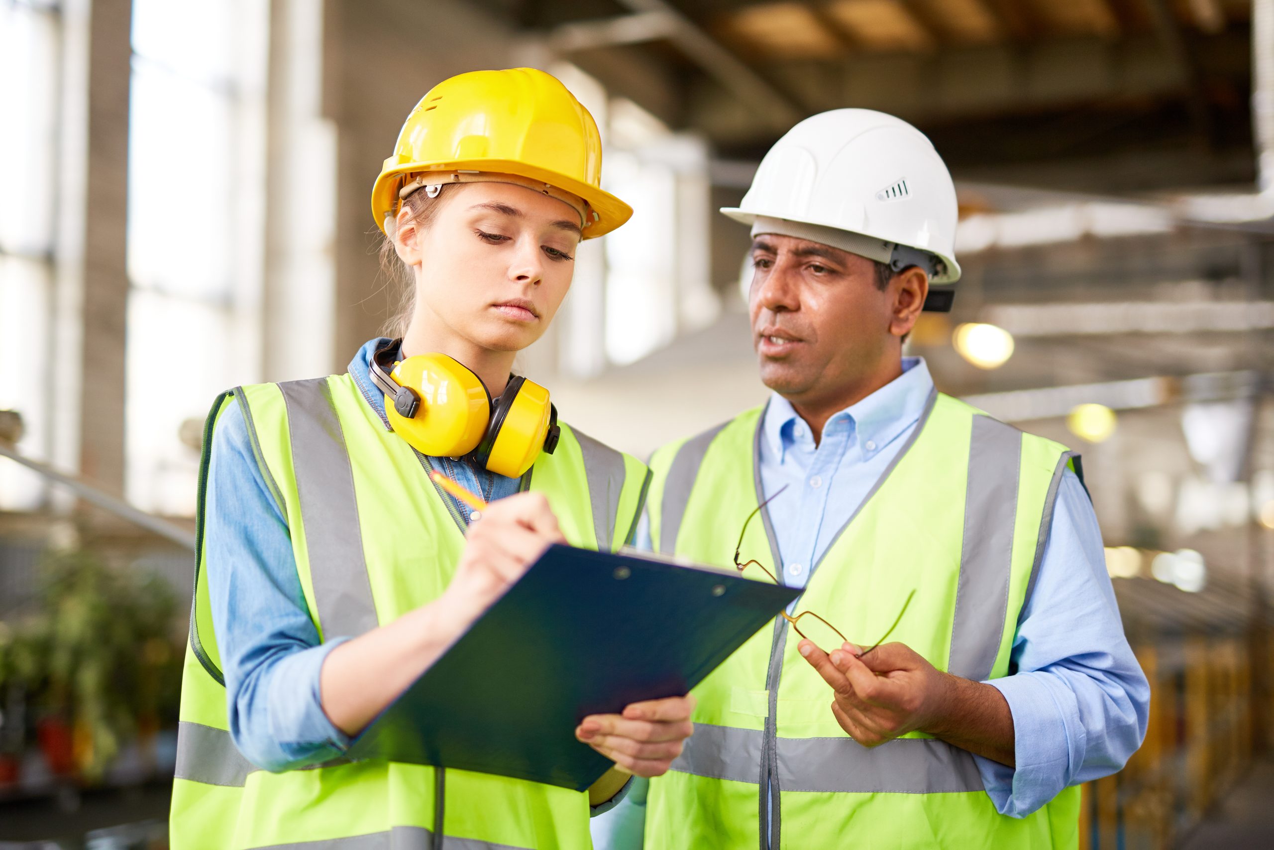 Engineer making notes whilst listening to the foreman