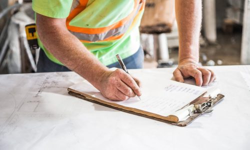 person-writing-on-paper-on-top-of-table-544965 Construction worker filling out risk assessment form